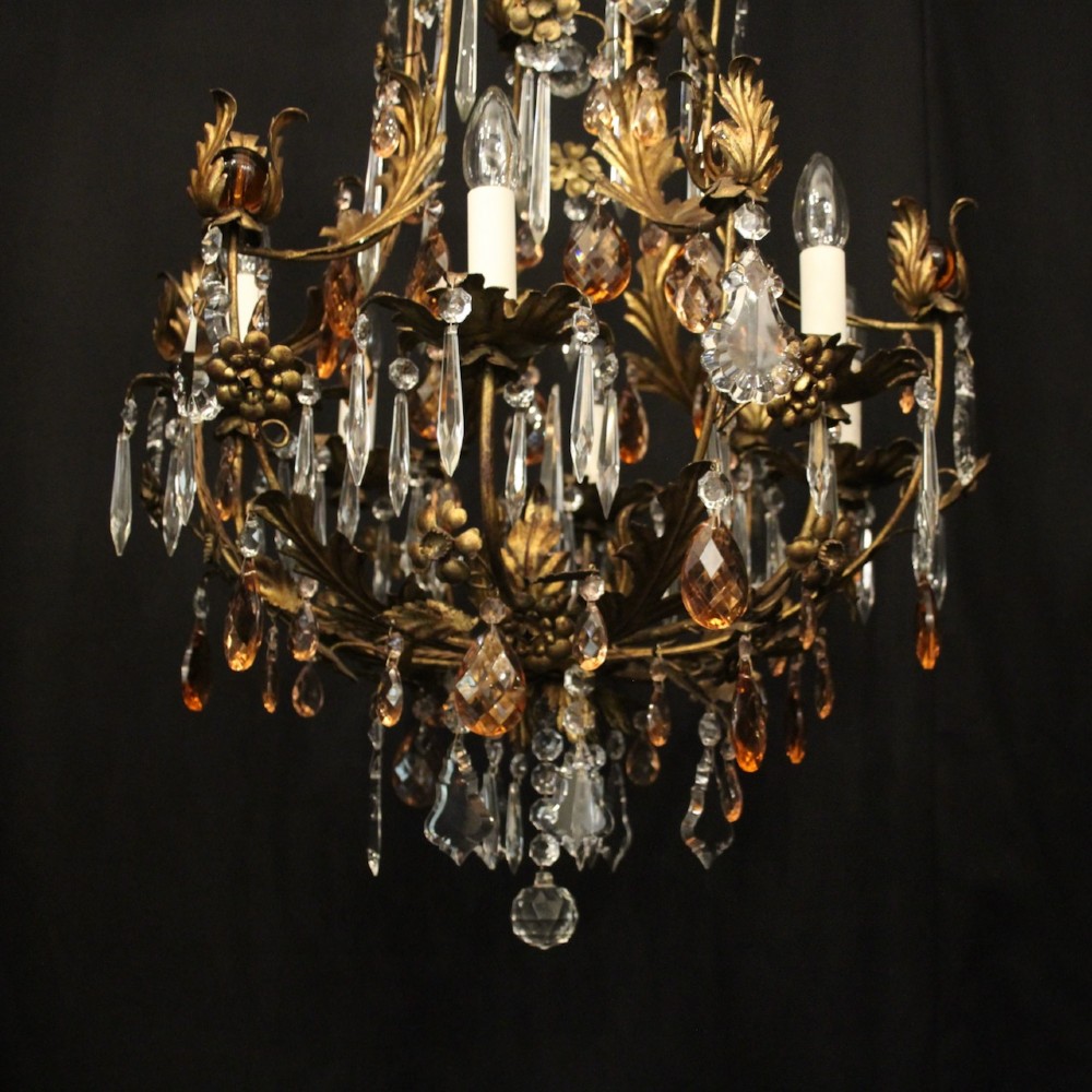 A six-light Florentine chandelier crafted with a gilded leaf metal frame and decorated with suspended clear and amber glass crystal droplets. View V