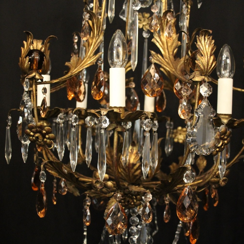 A six-light Florentine chandelier crafted with a gilded leaf metal frame and decorated with suspended clear and amber glass crystal droplets. View VI