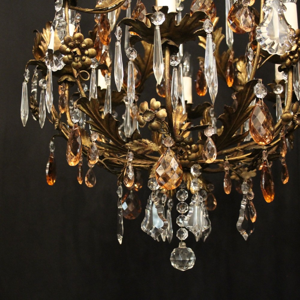 A six-light Florentine chandelier crafted with a gilded leaf metal frame and decorated with suspended clear and amber glass crystal droplets. View VIII