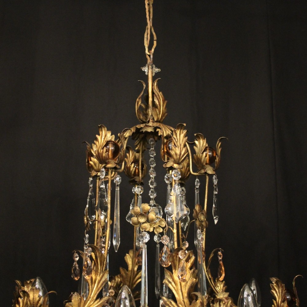 A six-light Florentine chandelier crafted with a gilded leaf metal frame and decorated with suspended clear and amber glass crystal droplets. View IX