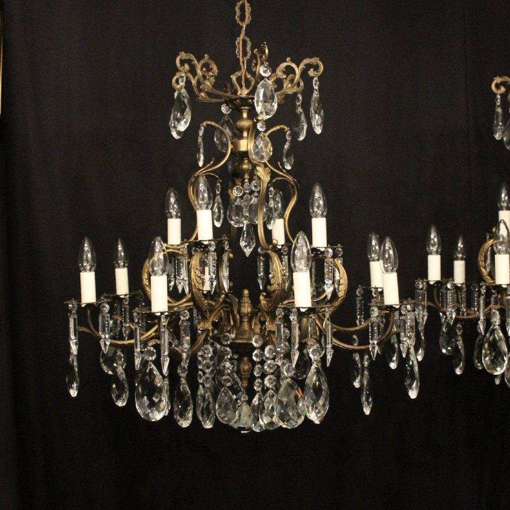 A pair of tiered French brass chandeliers featuring twelve lights each and clear glass crystal drops. View II