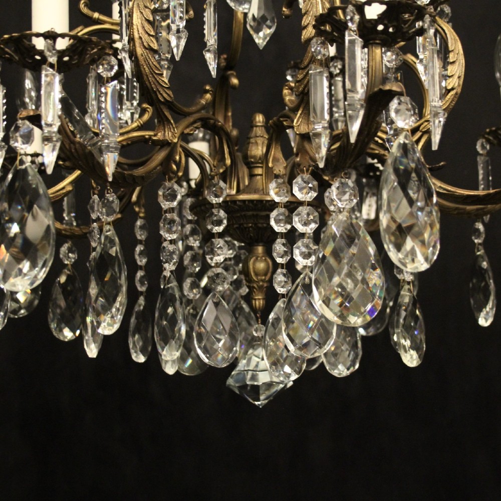 A pair of tiered French brass chandeliers featuring twelve lights each and clear glass crystal drops. View X