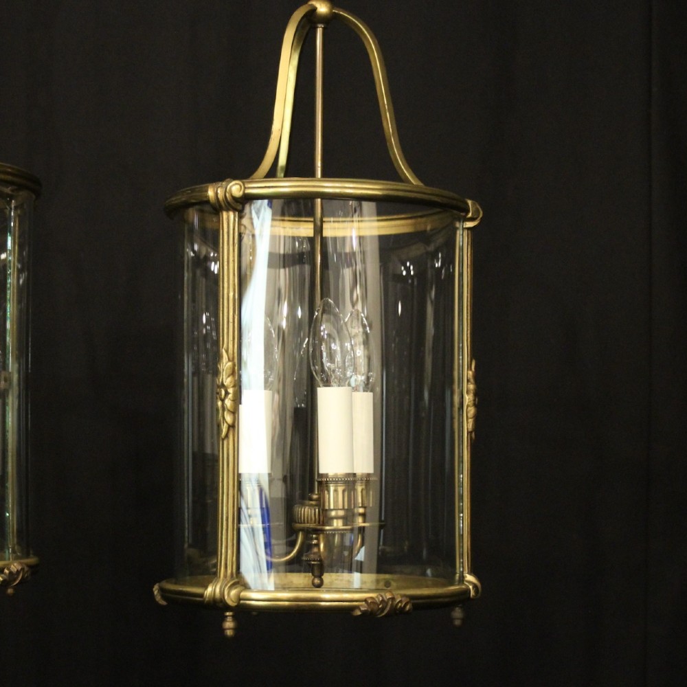 A pair of cylindrical French gilt bronze hanging hall lanterns featuring curved glass panels and internal candle-style light fittings. View III