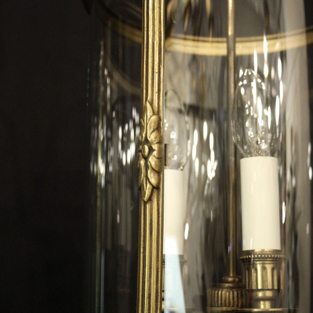 A pair of cylindrical French gilt bronze hanging hall lanterns featuring curved glass panels and internal candle-style light fittings. View VII