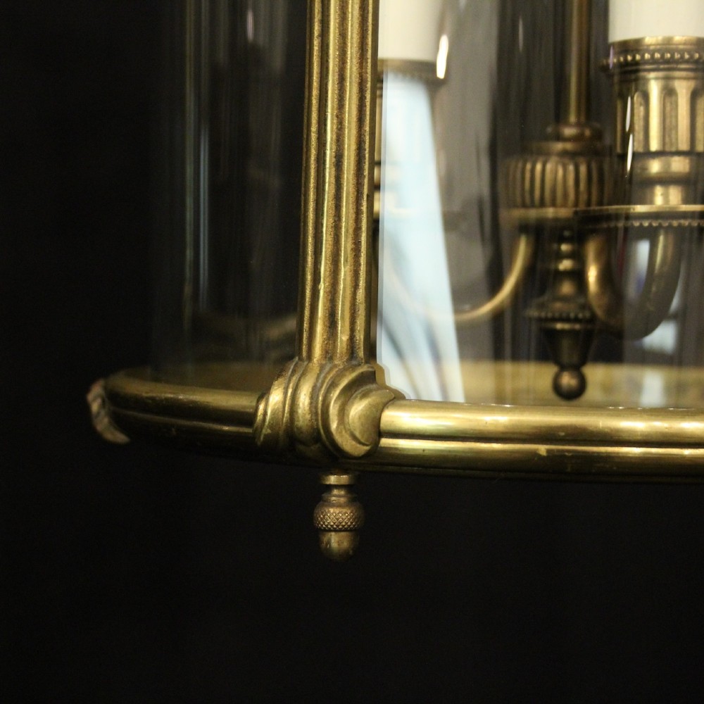 A pair of cylindrical French gilt bronze hanging hall lanterns featuring curved glass panels and internal candle-style light fittings. View VIII