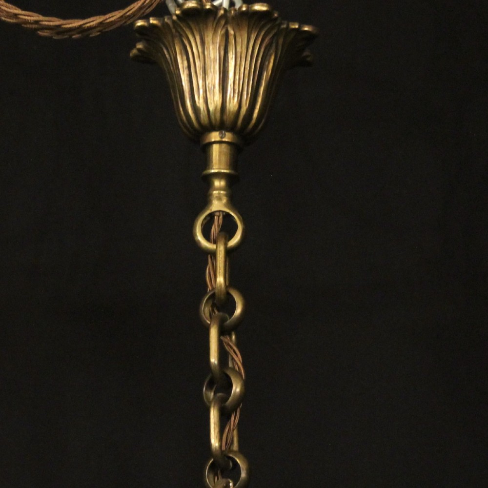 A pair of cylindrical French gilt bronze hanging hall lanterns featuring curved glass panels and internal candle-style light fittings. View X