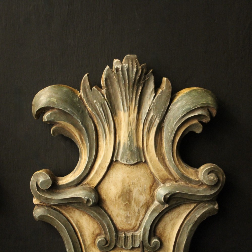A pair of carved Italian Florentine wall sconces in distressed cream and sage green paint, featuring acanthus crests and single metal candle prickets. View VII