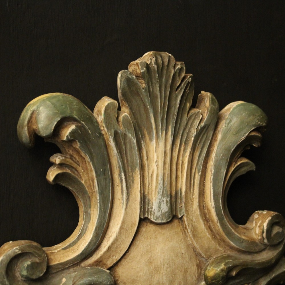 A pair of carved Italian Florentine wall sconces in distressed cream and sage green paint, featuring acanthus crests and single metal candle prickets. View VIII