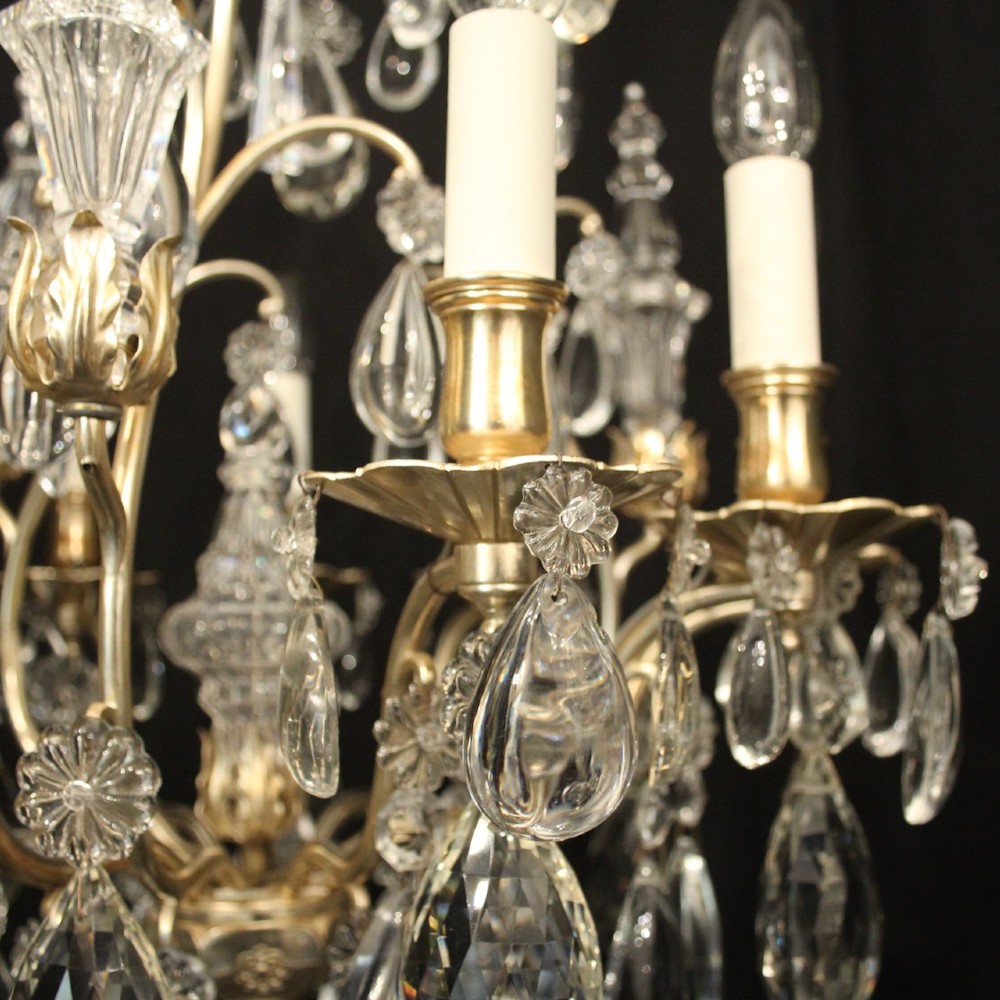 A French nine-light antique chandelier featuring a silver gilded metal frame adorned with cut crystal teardrop pendants and central glass baluster. View VII