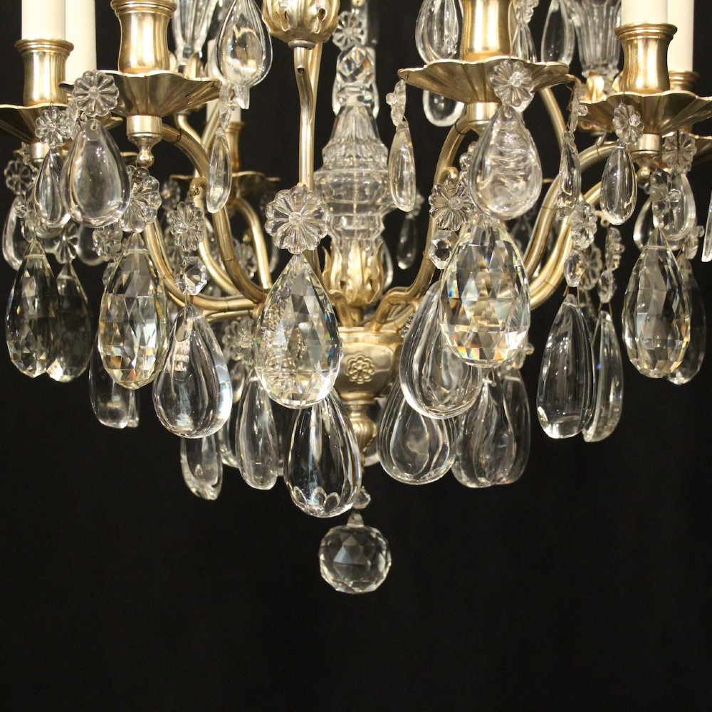 A French nine-light antique chandelier featuring a silver gilded metal frame adorned with cut crystal teardrop pendants and central glass baluster. View VIII