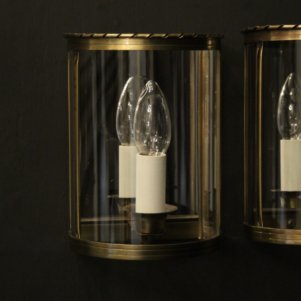 A pair of French brass convex half lanterns with curved glass panels and twin candle bulb sockets. View II