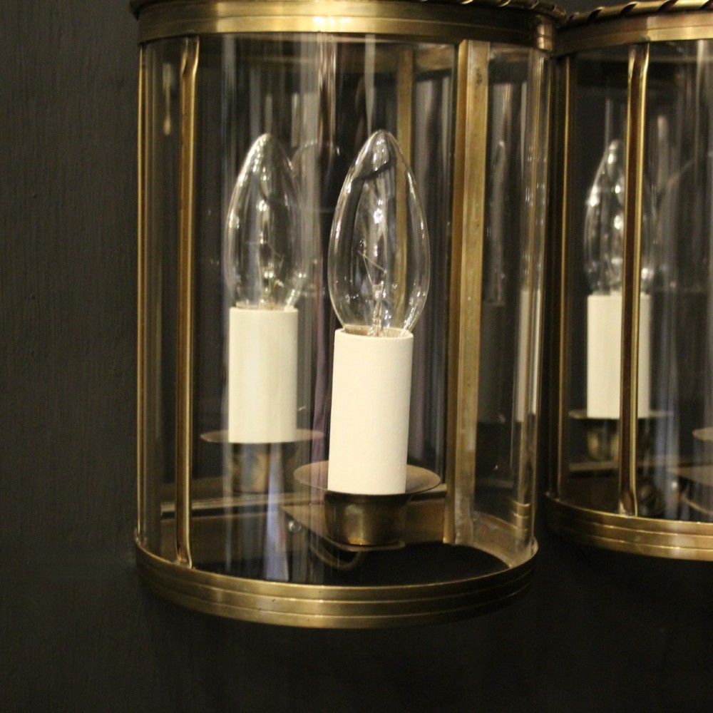 A pair of French brass convex half lanterns with curved glass panels and twin candle bulb sockets. View IV