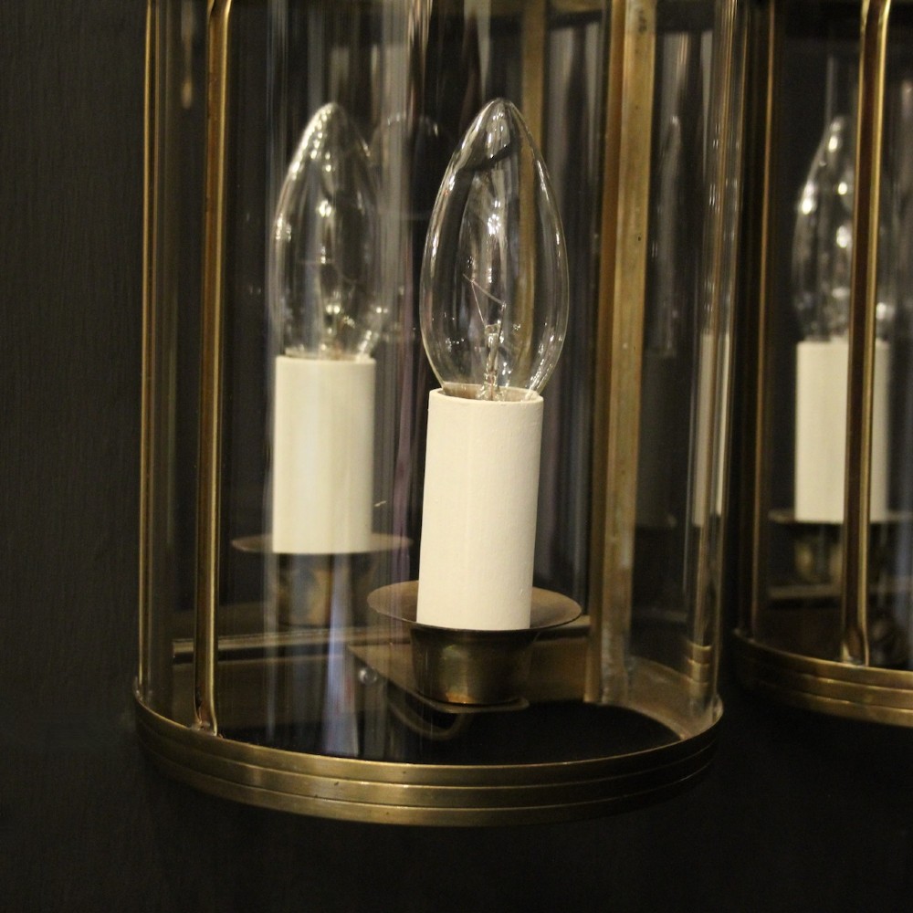 A pair of French brass convex half lanterns with curved glass panels and twin candle bulb sockets. View V