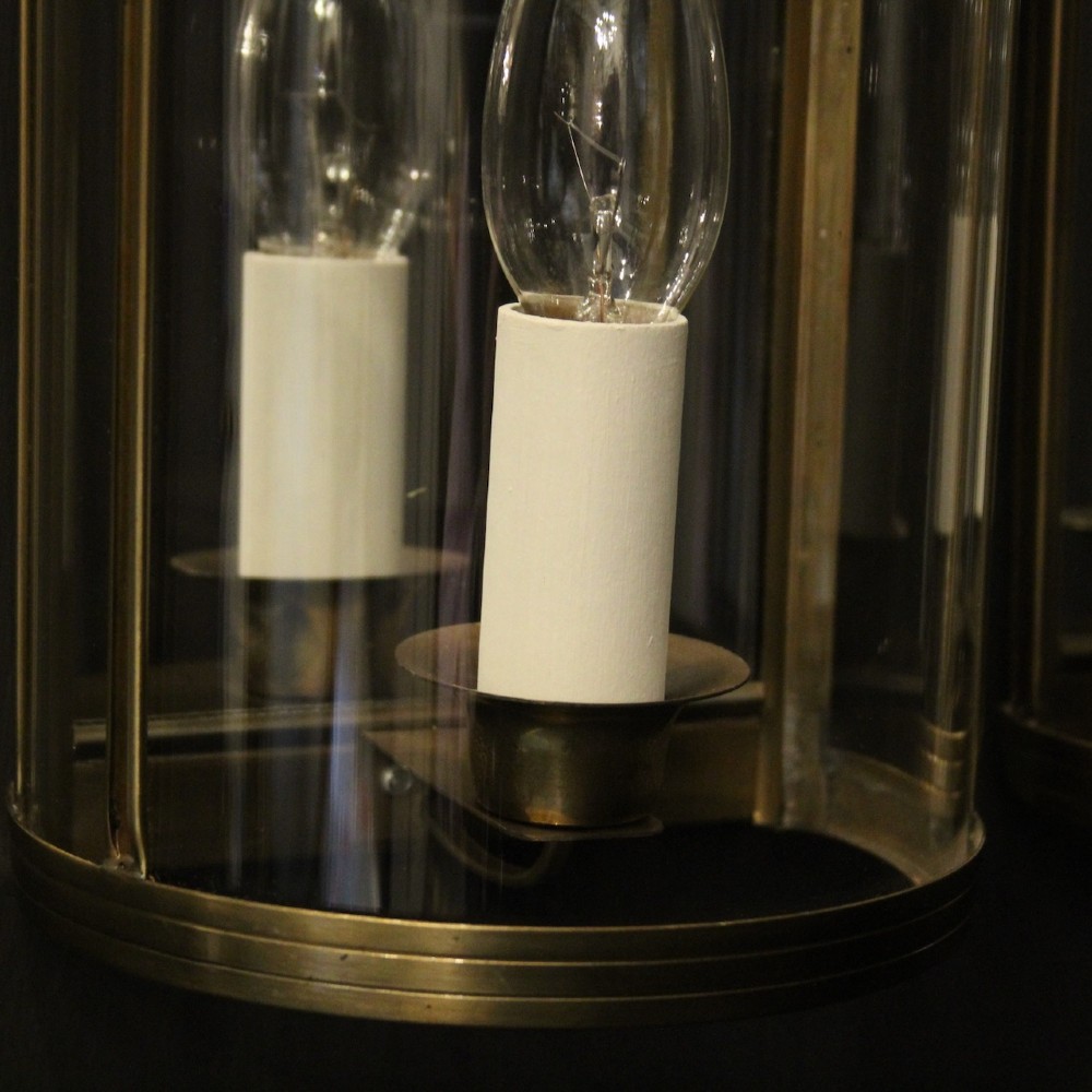 A pair of French brass convex half lanterns with curved glass panels and twin candle bulb sockets. View VI
