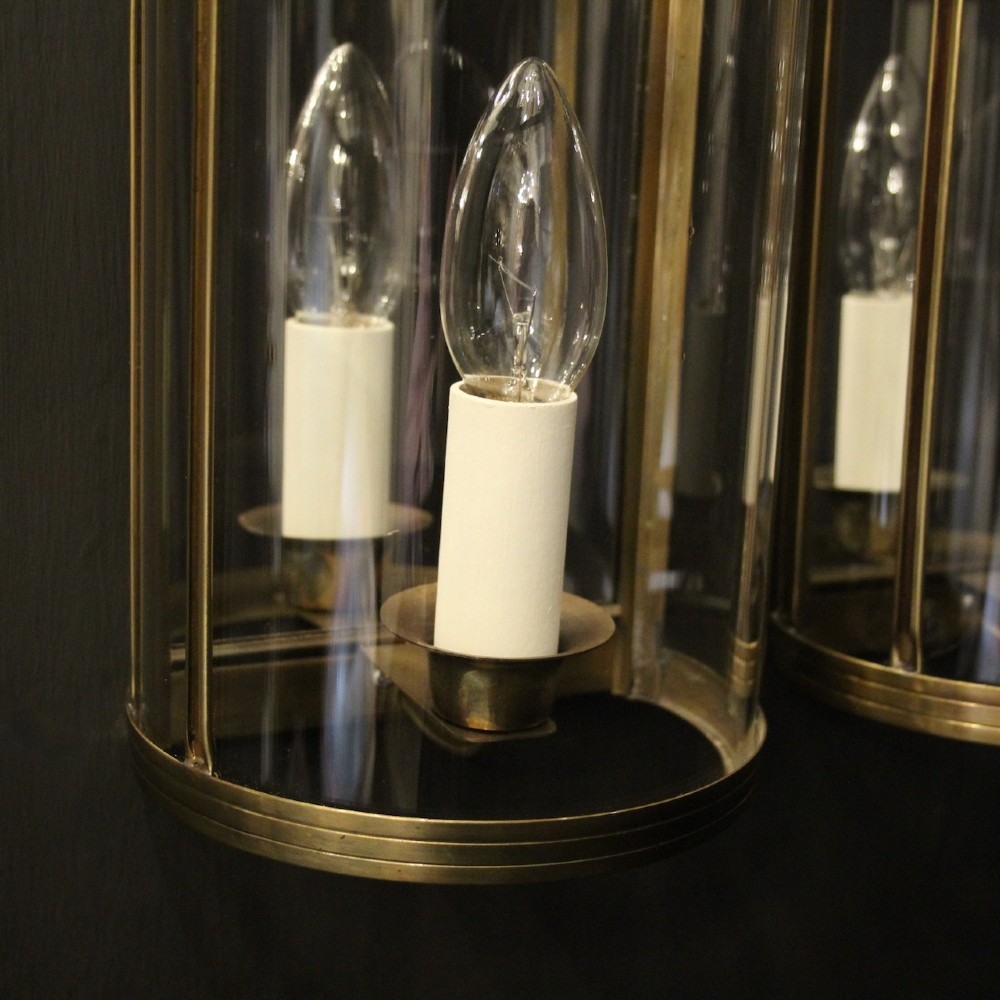 A pair of French brass convex half lanterns with curved glass panels and twin candle bulb sockets. View IX