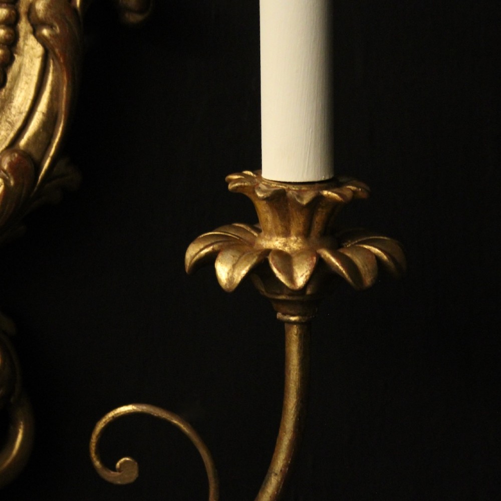 A pair of carved giltwood twin-arm girandole wall sconces featuring central circular mirrors, ornate scrollwork, and bow-tied cresting. View VIII