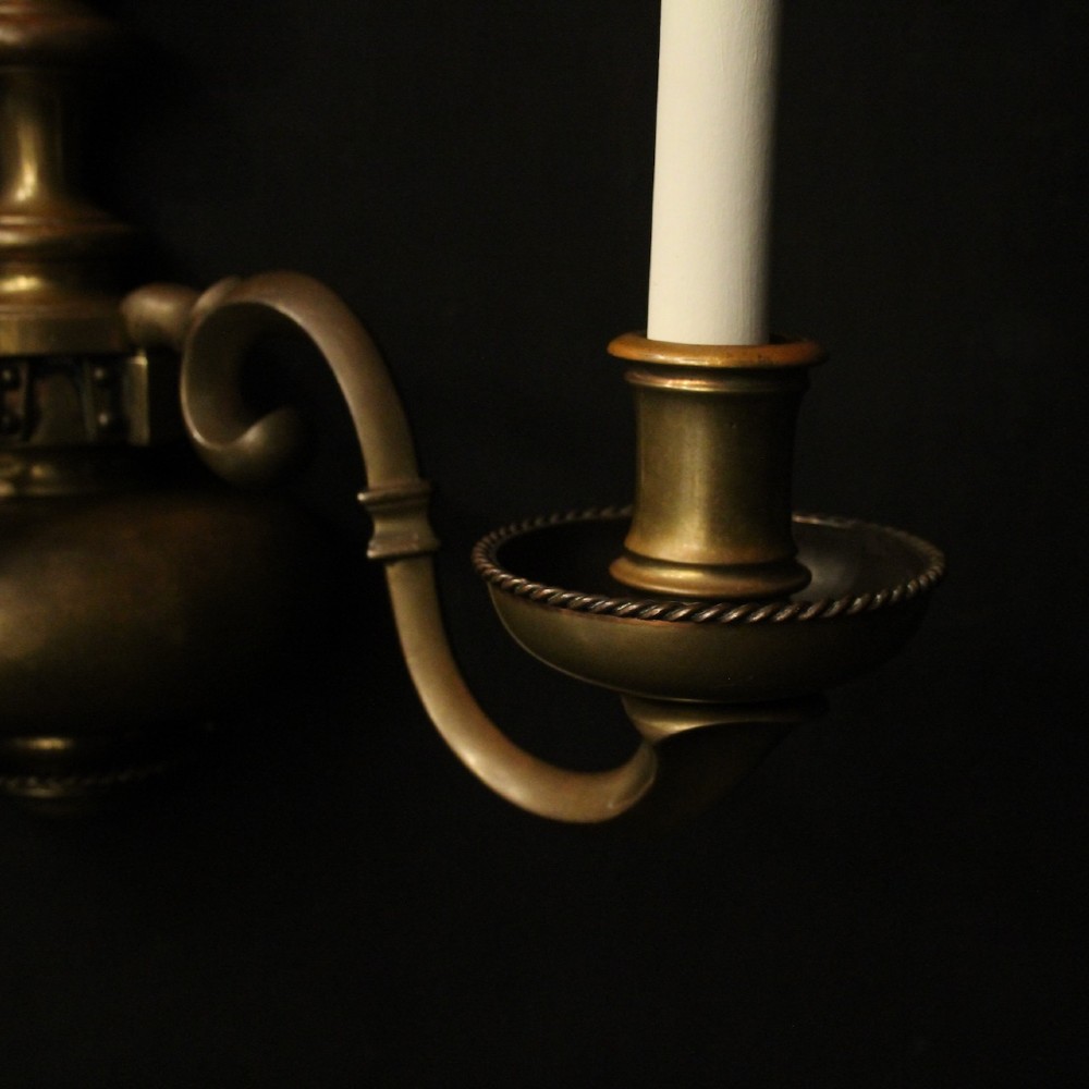 A set of three antique bronze wall sconces, each featuring a turned central baluster and two scrolled arms holding candle-style bulb holders. View III