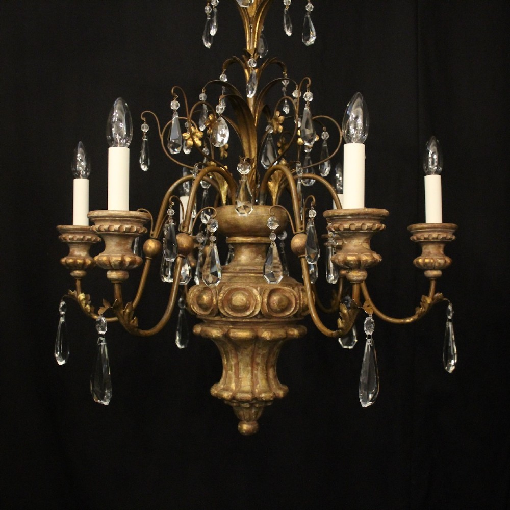 An antique Italian Florentine six-arm chandelier featuring gilded scrolling branches, a carved central column, white candle sleeves, and hanging crystal droplets. View II