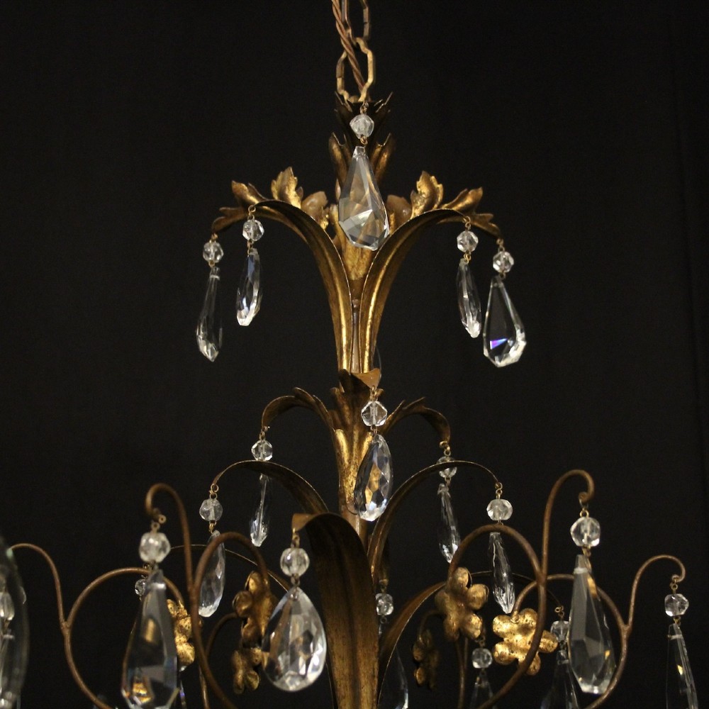 An antique Italian Florentine six-arm chandelier featuring gilded scrolling branches, a carved central column, white candle sleeves, and hanging crystal droplets. View VII