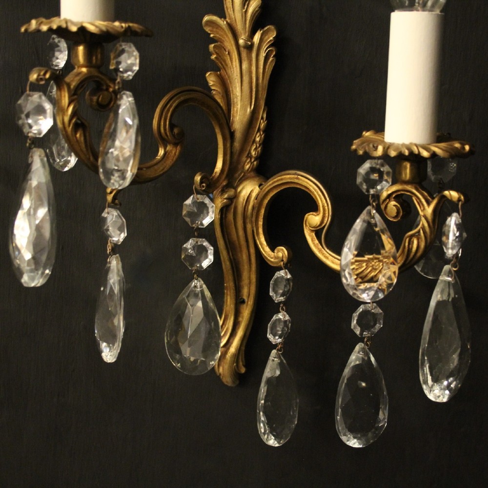 A pair of antique French gilt metal twin-arm wall sconces decorated with cut crystal teardrop pendants. View IV