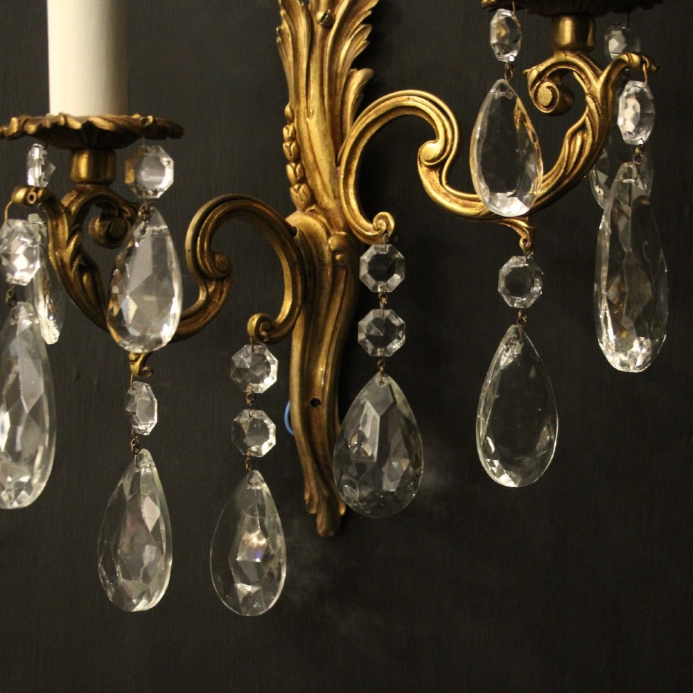A pair of antique French gilt metal twin-arm wall sconces decorated with cut crystal teardrop pendants. View VI