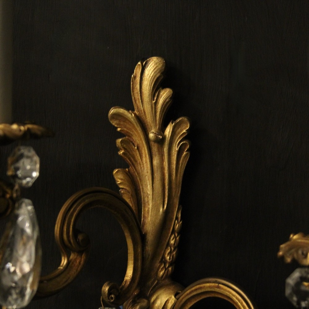 A pair of antique French gilt metal twin-arm wall sconces decorated with cut crystal teardrop pendants. View VII
