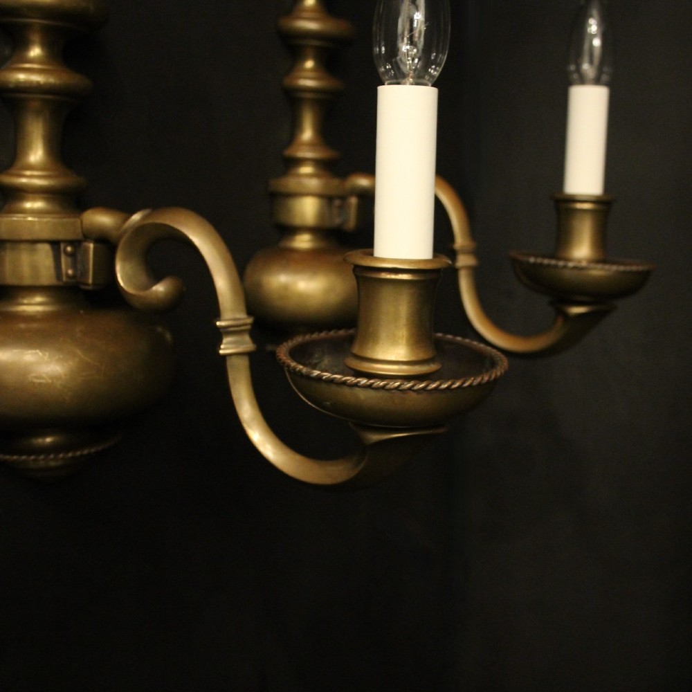 A pair of antique bronze single-arm wall lights with turned baluster shafts and candle-style fittings against a dark background. View VI