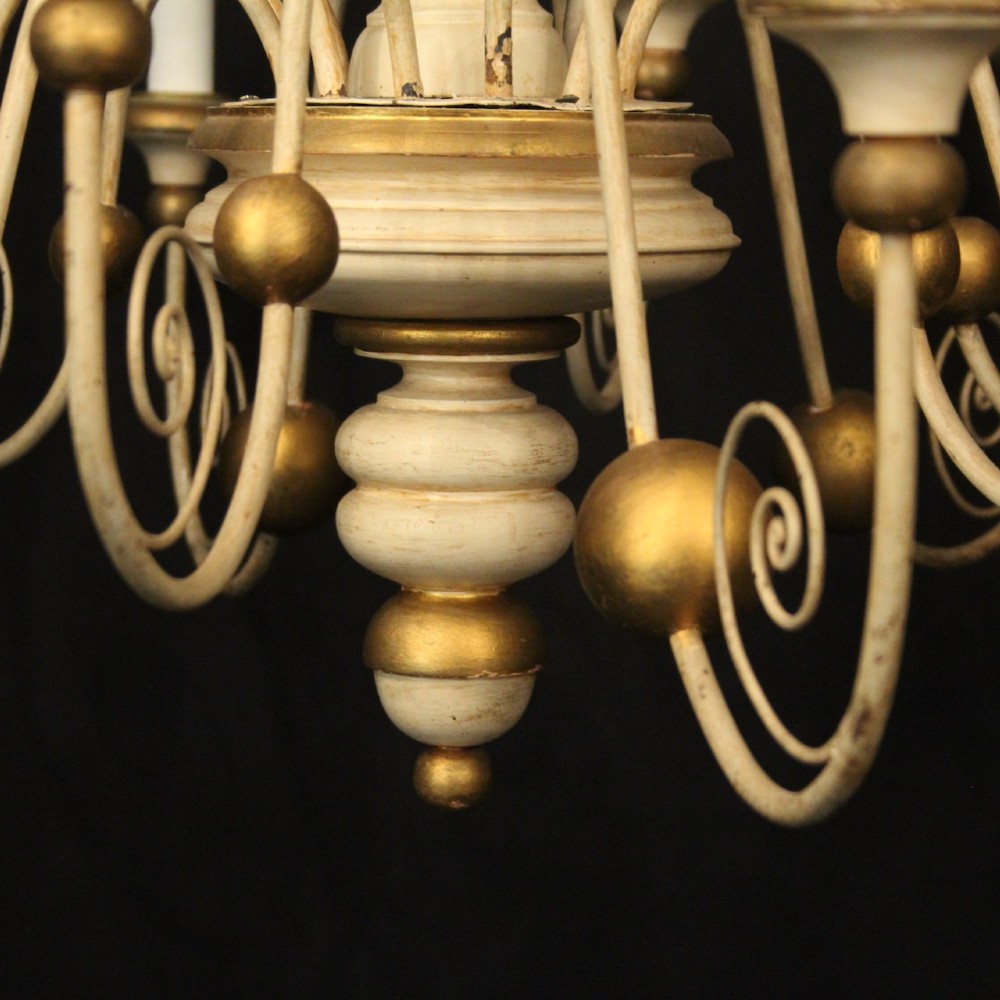 A twelve-light Florentine style ceiling chandelier featuring a cream and gilded turned wooden central column with wrought scrollwork branch arms and candle sleeves. View VIII