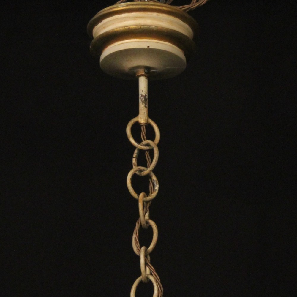 A twelve-light Florentine style ceiling chandelier featuring a cream and gilded turned wooden central column with wrought scrollwork branch arms and candle sleeves. View X