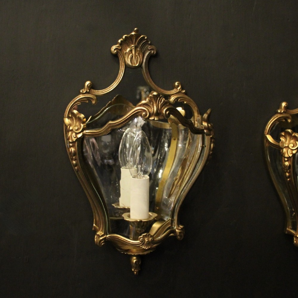 A pair of French gilded bronze half lanterns featuring curved glass panels and decorative palmette cresting, mounted as wall sconces. View II