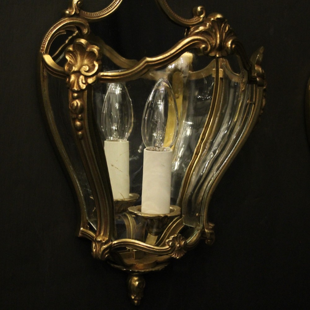 A pair of French gilded bronze half lanterns featuring curved glass panels and decorative palmette cresting, mounted as wall sconces. View III