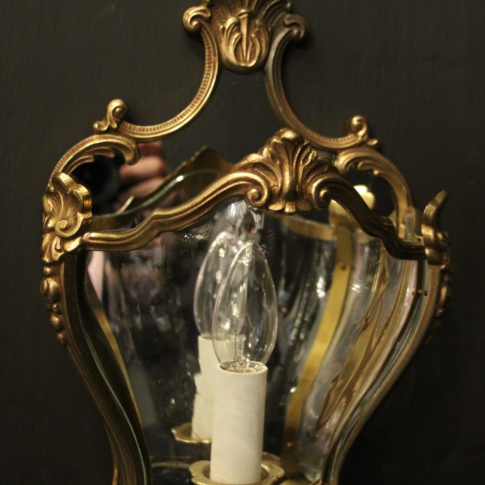 A pair of French gilded bronze half lanterns featuring curved glass panels and decorative palmette cresting, mounted as wall sconces. View IV