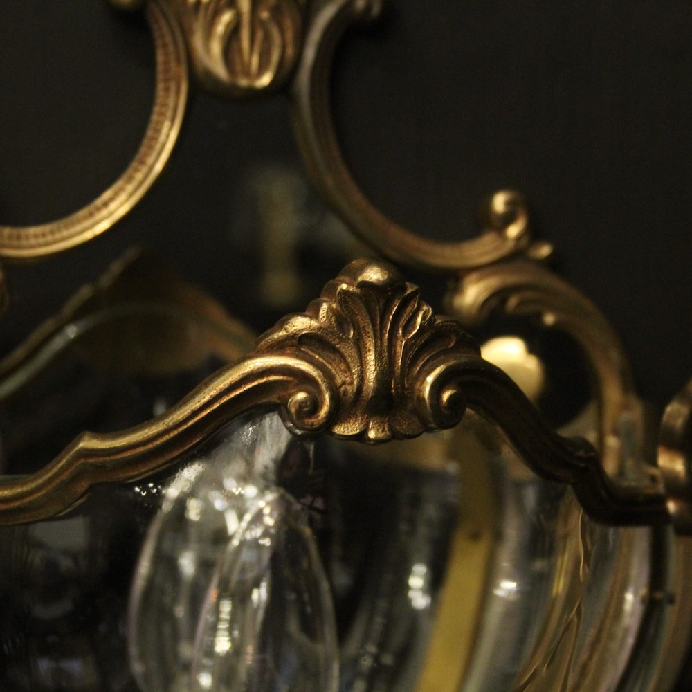 A pair of French gilded bronze half lanterns featuring curved glass panels and decorative palmette cresting, mounted as wall sconces. View V