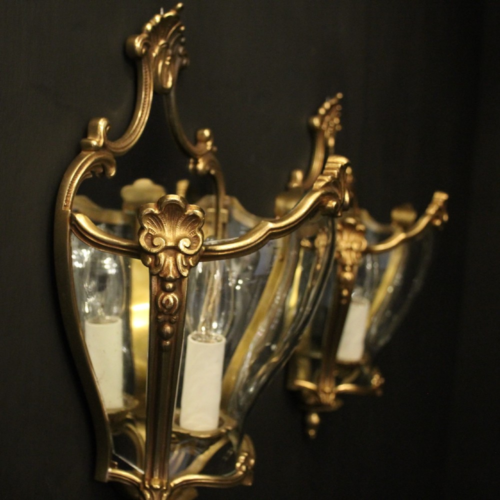 A pair of French gilded bronze half lanterns featuring curved glass panels and decorative palmette cresting, mounted as wall sconces. View VI