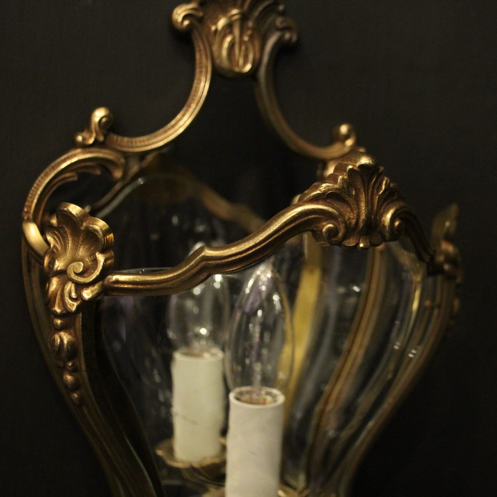A pair of French gilded bronze half lanterns featuring curved glass panels and decorative palmette cresting, mounted as wall sconces. View VII