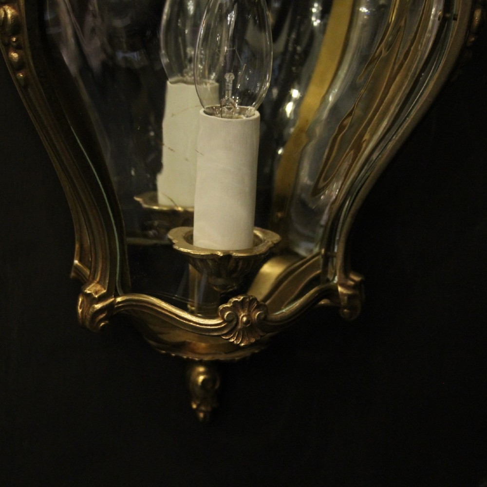 A pair of French gilded bronze half lanterns featuring curved glass panels and decorative palmette cresting, mounted as wall sconces. View VIII