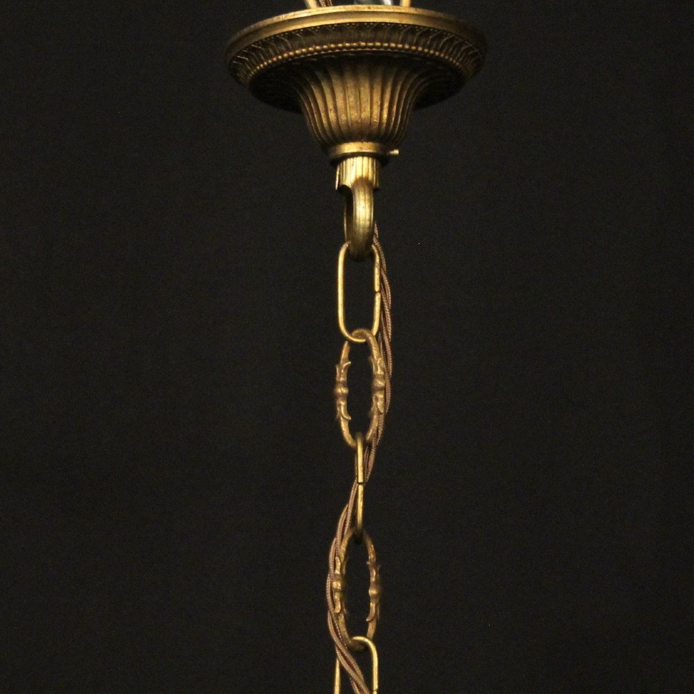 A cylindrical French gilded brass hall lantern featuring three central candle light fittings, curved top scrolls, floral garlands, and clear glass panes. View X