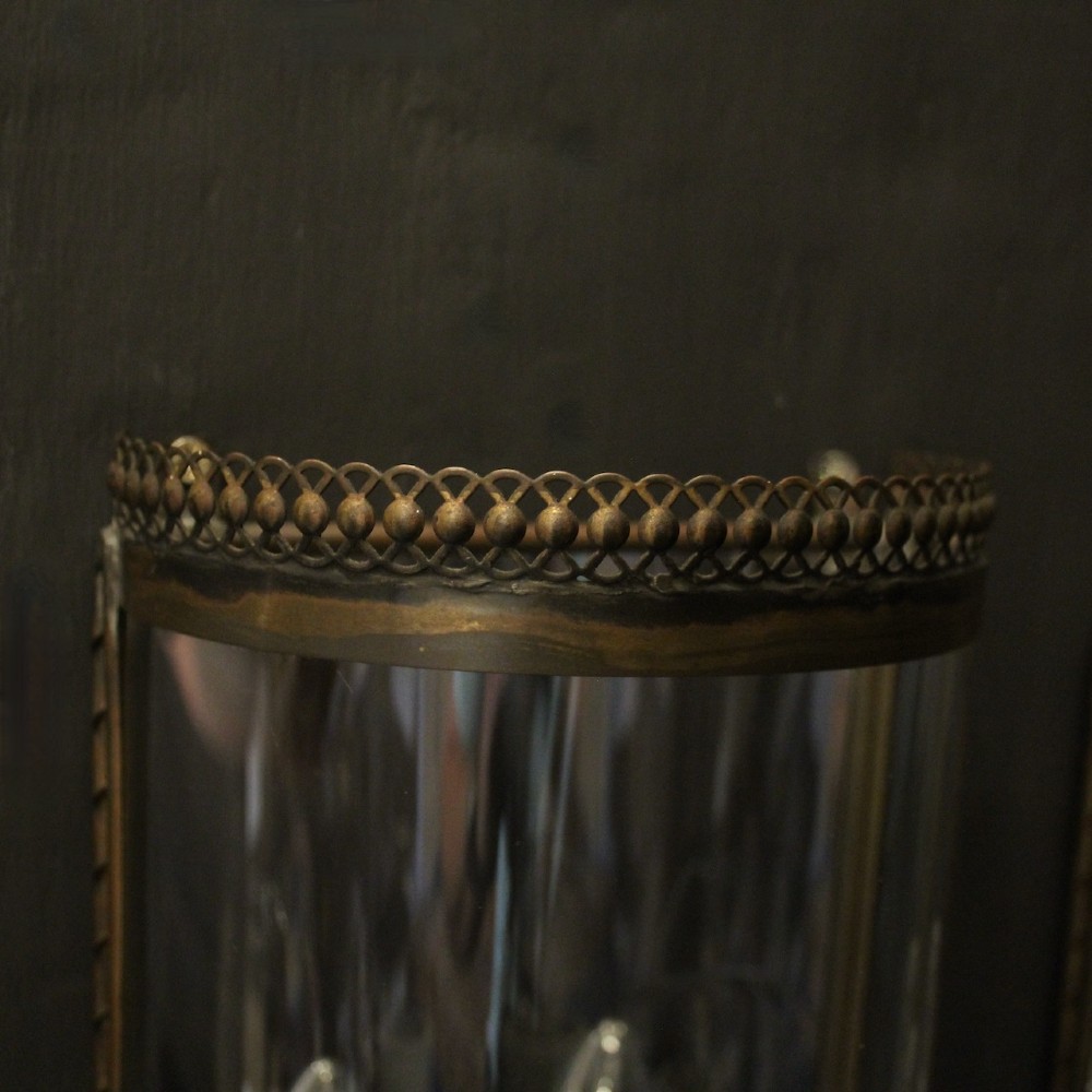 A pair of semi-circular brass half-lantern wall sconces featuring curved clear glass panels and four faux candle-bulb fittings inside each unit. View VI