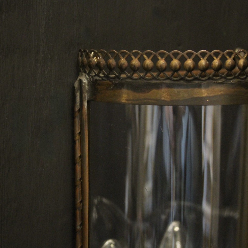 A pair of semi-circular brass half-lantern wall sconces featuring curved clear glass panels and four faux candle-bulb fittings inside each unit. View VII
