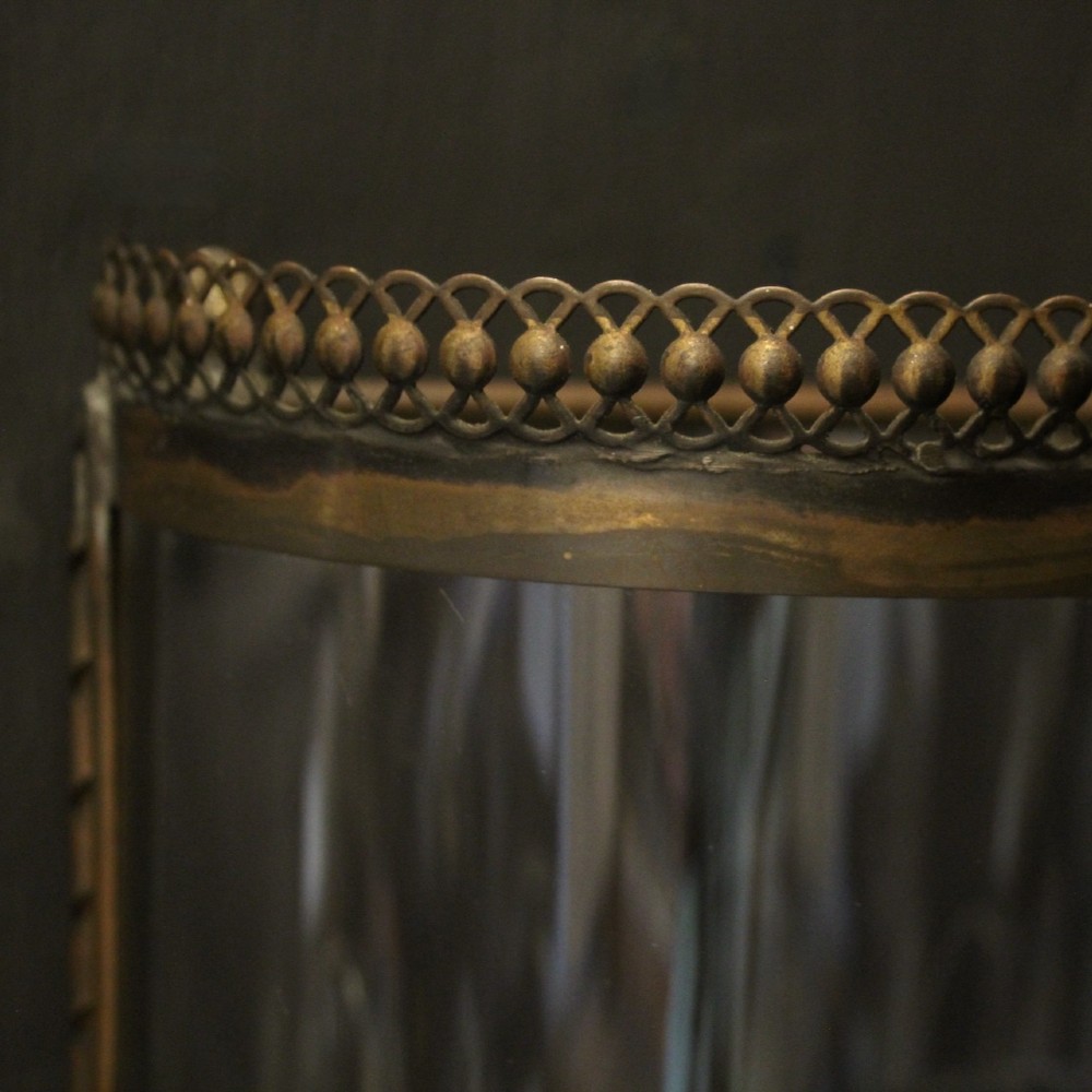 A pair of semi-circular brass half-lantern wall sconces featuring curved clear glass panels and four faux candle-bulb fittings inside each unit. View VIII