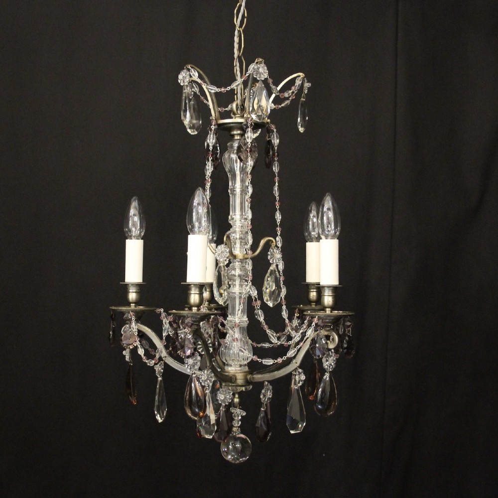 An antique French silver gilt five-light chandelier with clear and tinted crystal teardrop pendants, bead strands, and candle-style bulb sockets.