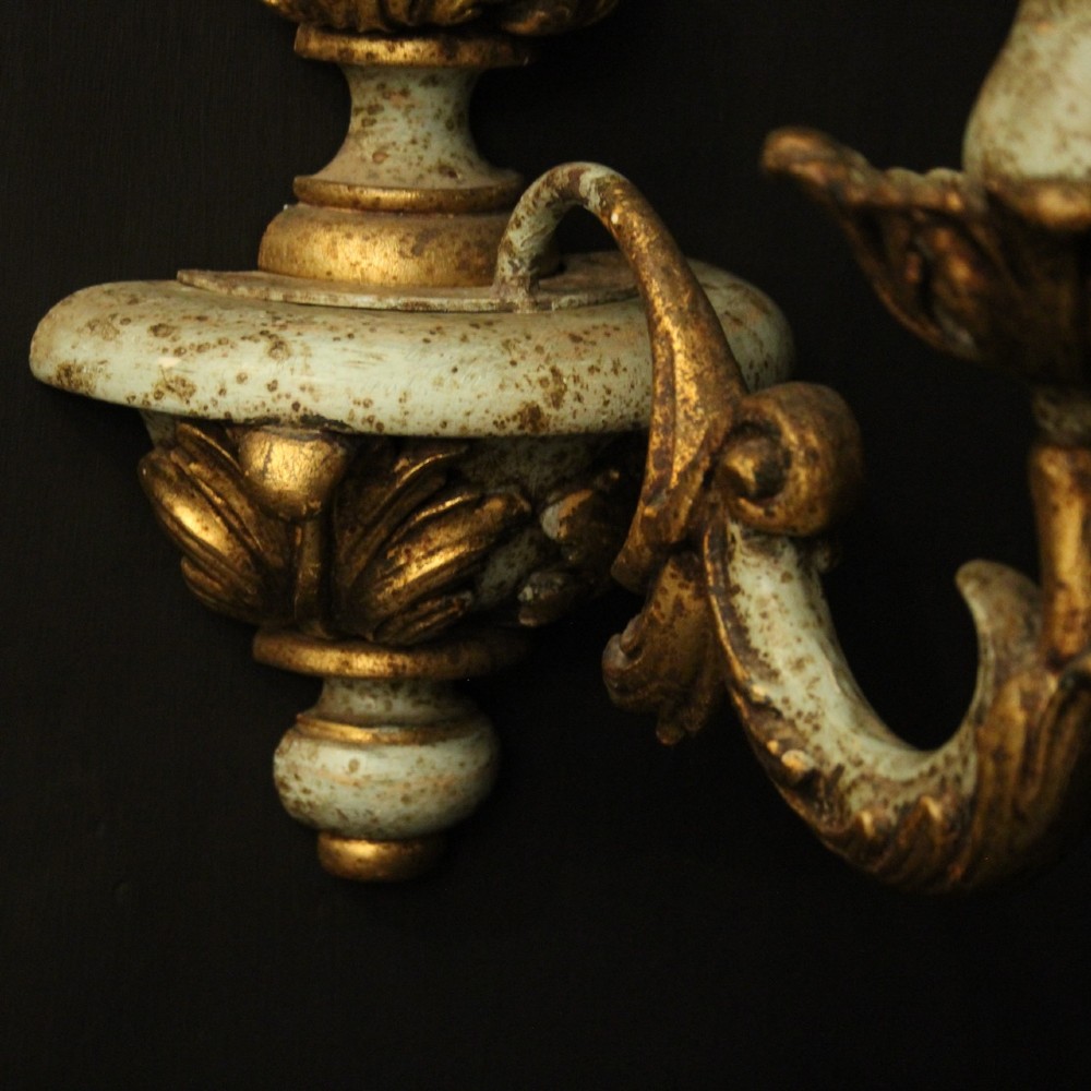 A pair of antique Italian wall lights featuring turned polychrome stems in pale green and gold with carved leaf accents and single candlestick arms. View VIII