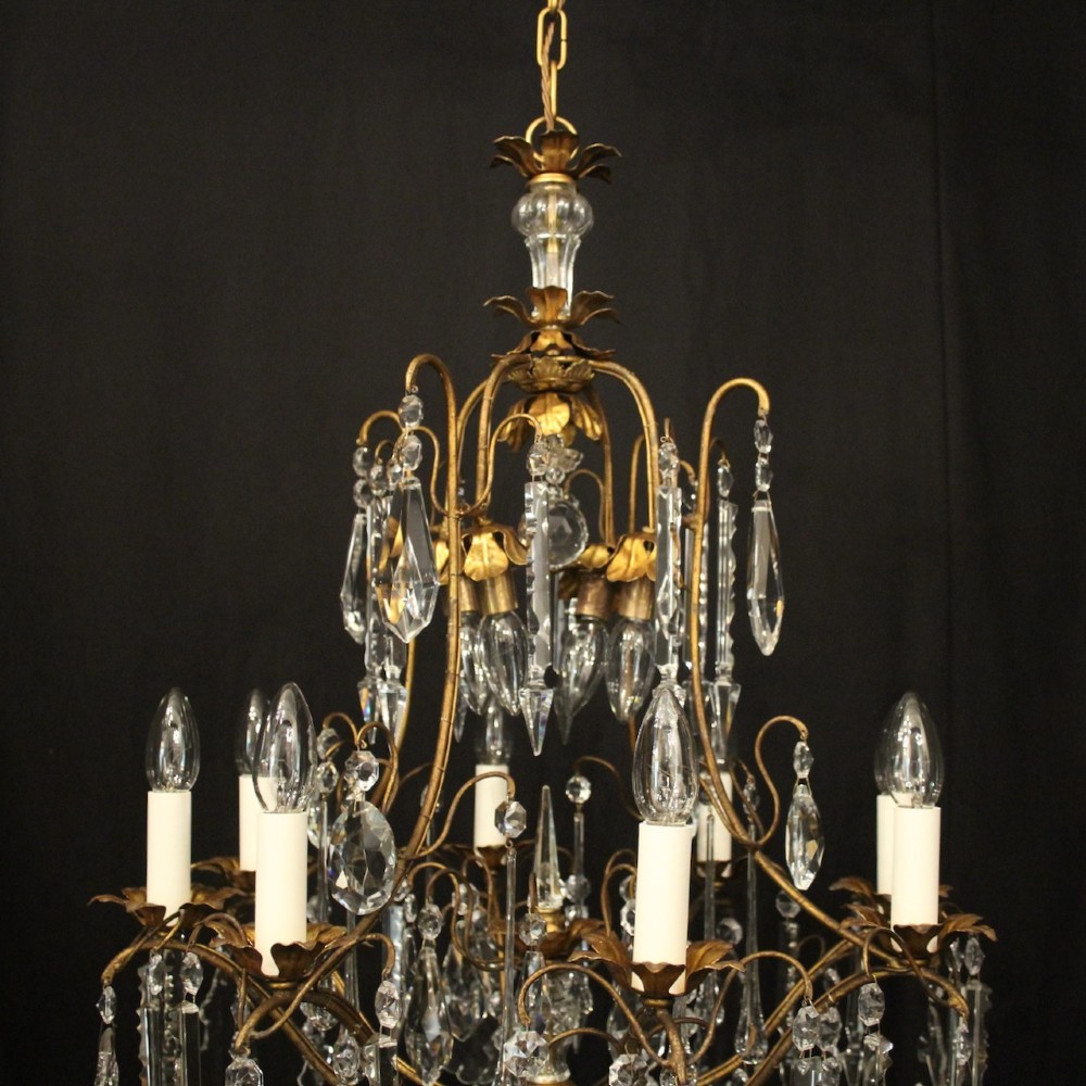 A multi-tiered French gilded brass chandelier adorned with cut crystal prisms and twelve faux candle light fittings. View VII