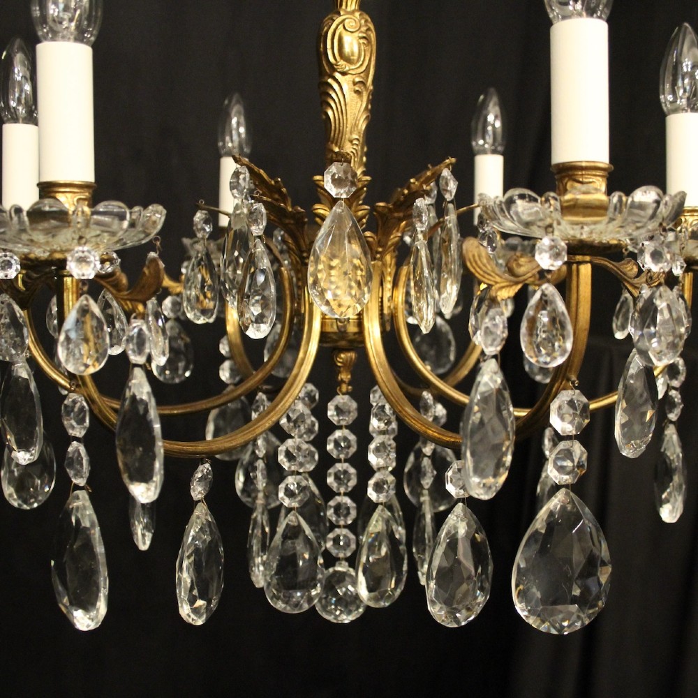 A six-arm French gilded brass chandelier decorated with faceted crystal drops and white candle-effect light sleeves. View VII