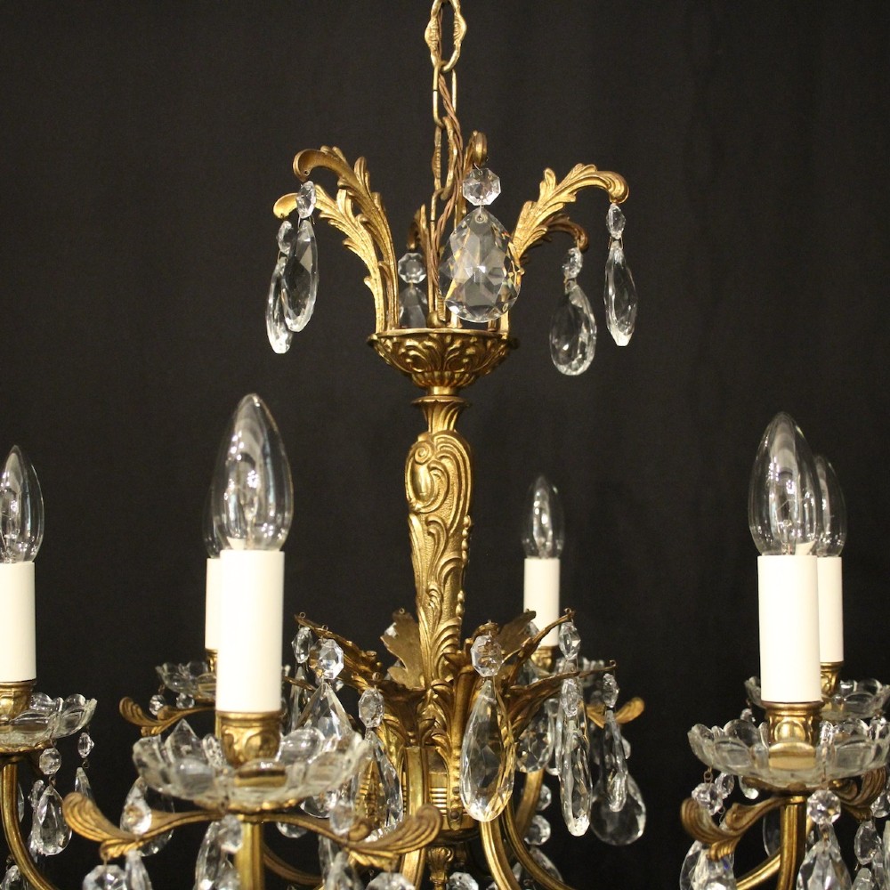 A six-arm French gilded brass chandelier decorated with faceted crystal drops and white candle-effect light sleeves. View VIII