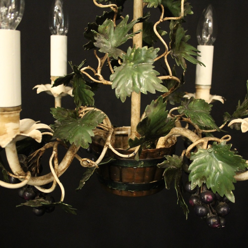 A French toleware four-light chandelier featuring cream candle sleeves, hand-painted green vine leaves, and dark grape clusters surrounding a central stem. View VI