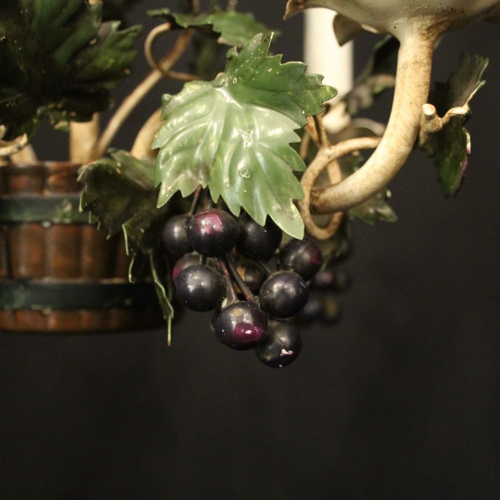 A French toleware four-light chandelier featuring cream candle sleeves, hand-painted green vine leaves, and dark grape clusters surrounding a central stem. View VII