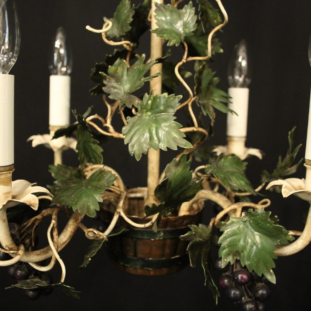 A French toleware four-light chandelier featuring cream candle sleeves, hand-painted green vine leaves, and dark grape clusters surrounding a central stem. View IX