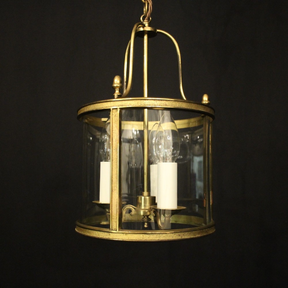 A French gilded brass hall lantern featuring a cylindrical glass shade enclosing three candle-style bulb holders suspended by an arched frame. View III