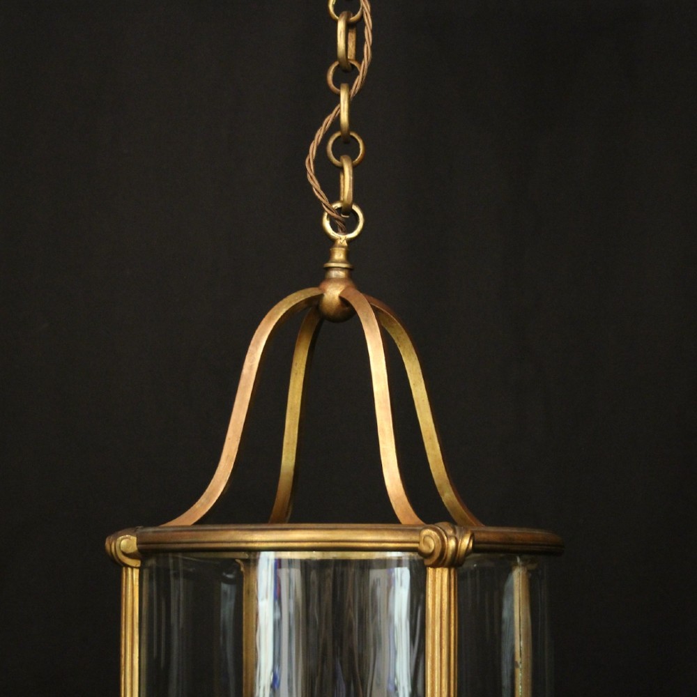 A cylindrical glass and gilt bronze hanging lantern featuring four internal candle sleeves, a looped upper crown, and a suspension chain. View VI